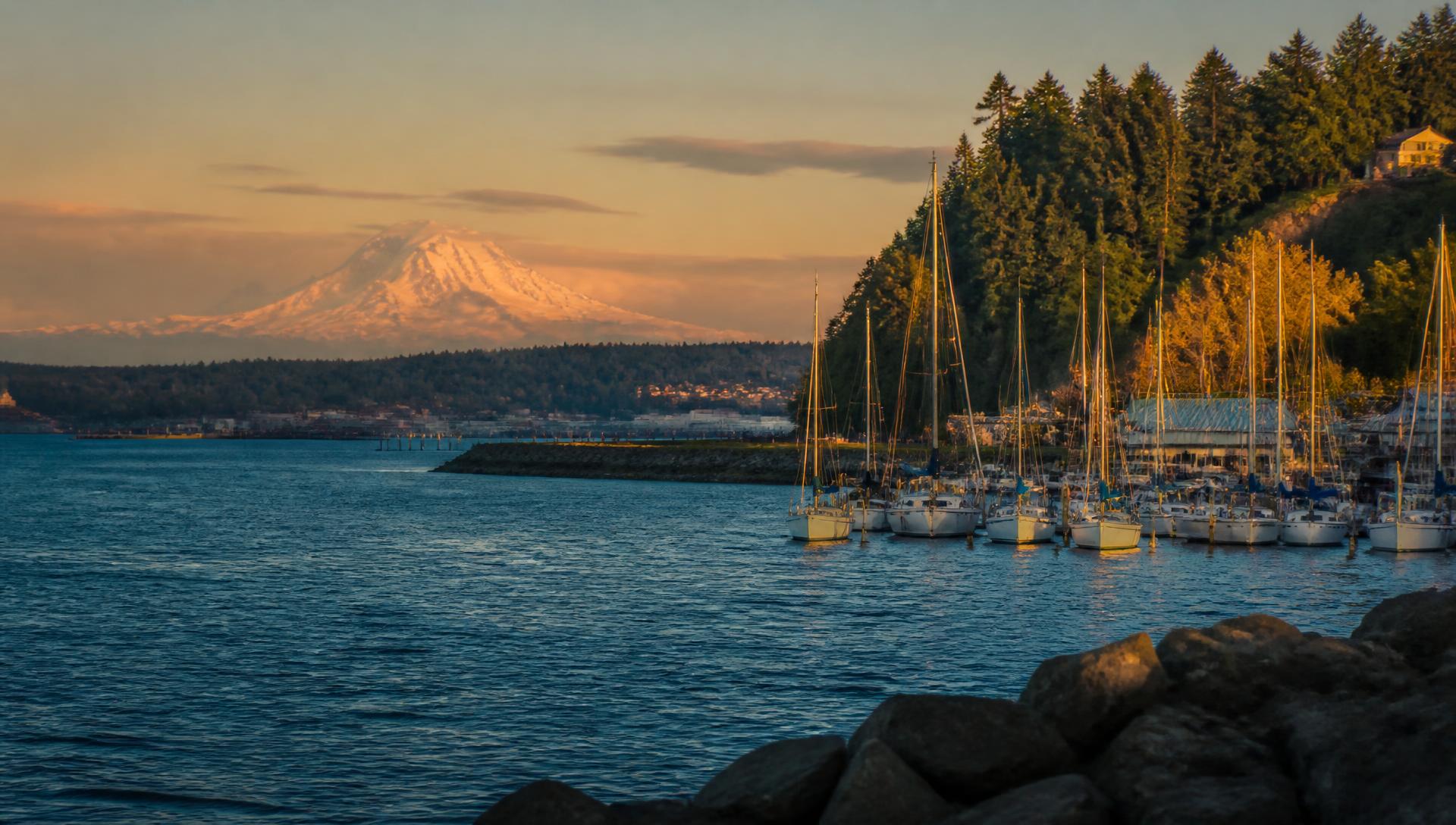 Golden-hour view across Commencement Bay in Tacoma with sailboats and Mount Rainier in the distance